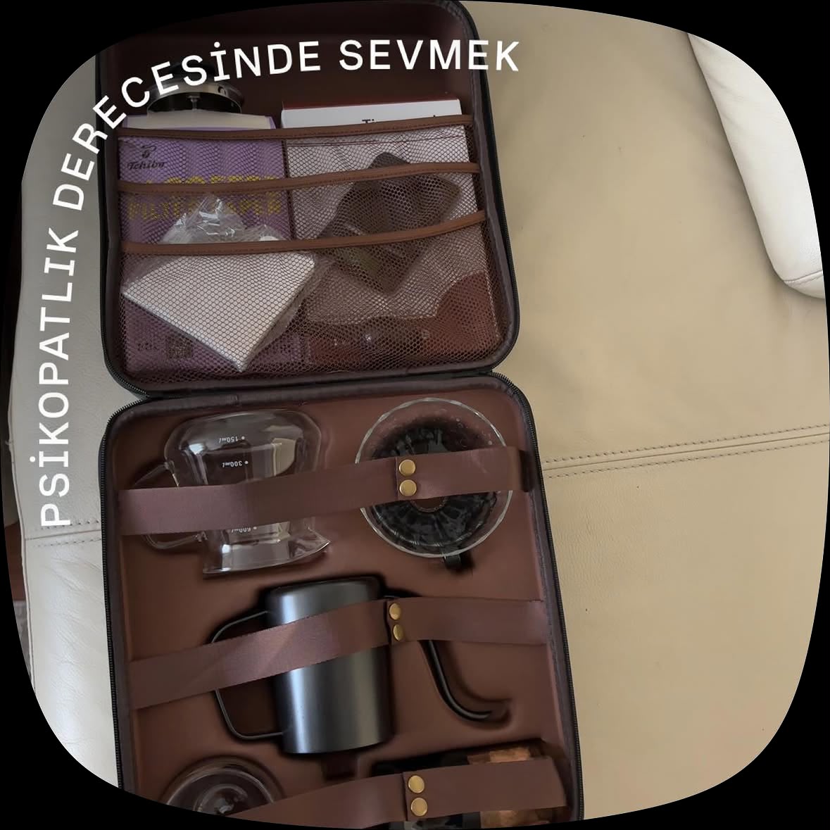 Açık taşıma çantasında cam karaf, dripper, filtreler ve siyah kuğu boyunlu kettle.